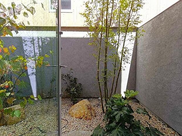 モダンな外壁の質感と、表情豊かな植栽・自然石・こだわりの間接照明が織りなす上質な佇まい。大きなガラス窓越しに室内のどこからでも緑を望め、暮らしの中に自然の潤いを感じられます。