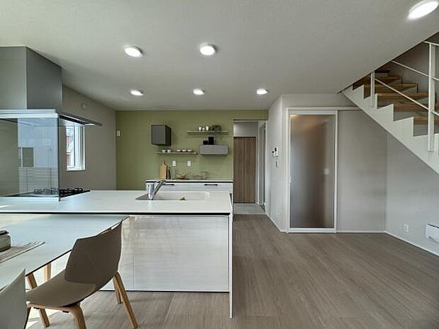 人気の対面キッチンを採用。配膳の動線など、家事ラクになるように考えました。背面のグリーンのアクセントクロスがポイントです!