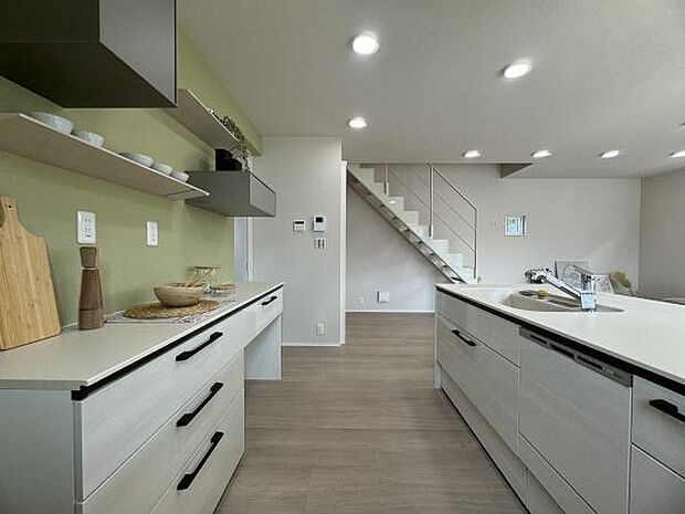 人気の対面キッチンを採用。配膳の動線など、家事ラクになるように考えました。背面のグリーンのアクセントクロスがポイントです！