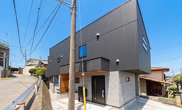 青空に映えるモダンな外観と、整備された外構。周辺環境とも調和し、長く愛着を持って住める一棟。