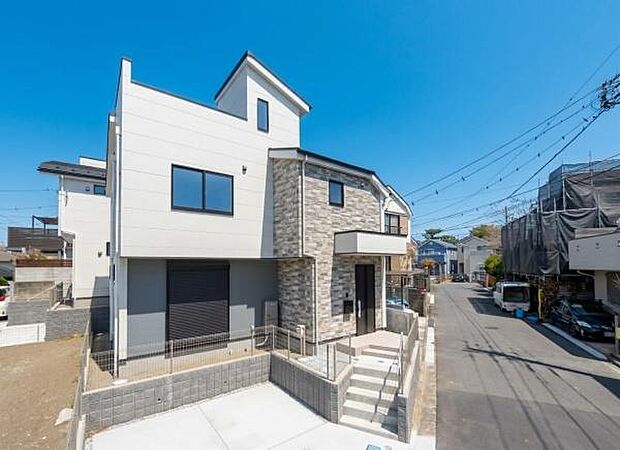 陽光に映えるモダンな邸宅。落ち着いた色調の外壁が、閑静な住宅街に調和し、品格ある住まいを演出します。