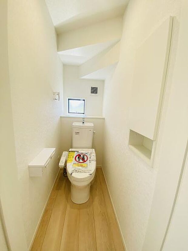広々したトイレには収納棚がついています。換気用小窓があり明るく清潔な空間です。