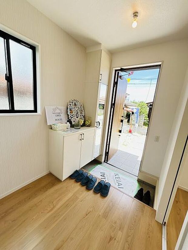 明るい光が差し込む玄関スペースです。収納も備え付けられており日々の使い勝手にも配慮されています。木目調の床が温かみを感じさせます。窓からの自然光も心地よく室内を照らします。開放感を感じられる空間です。