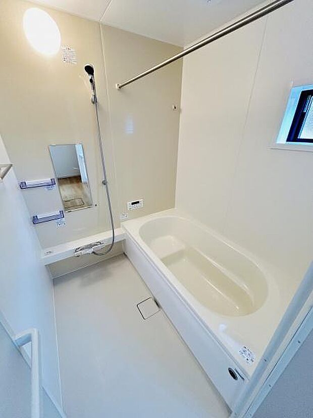 明るい照明と清潔感のあるバスルームです。小窓があり換気しやすい設計となっています。手すりも備わっており入浴の際に安心です。ゆったりとした浴槽で快適なバスタイムが楽しめます。ミラー付きで便利な仕様です。