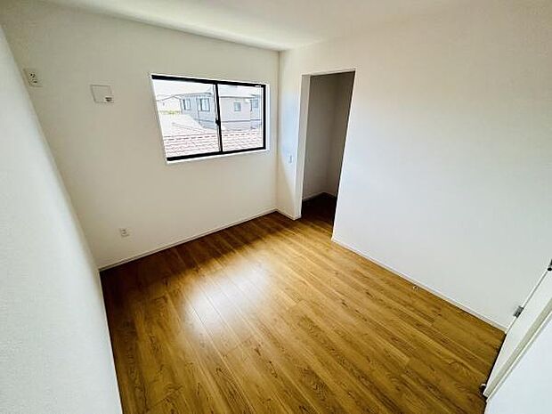 明るい光が差し込む洋室です。床は落ち着いた色合いのフローリング仕様となっています。スッキリとした空間で配置もしやすい間取りです。収納スペースも確保されています。窓からの眺望も楽しめます。