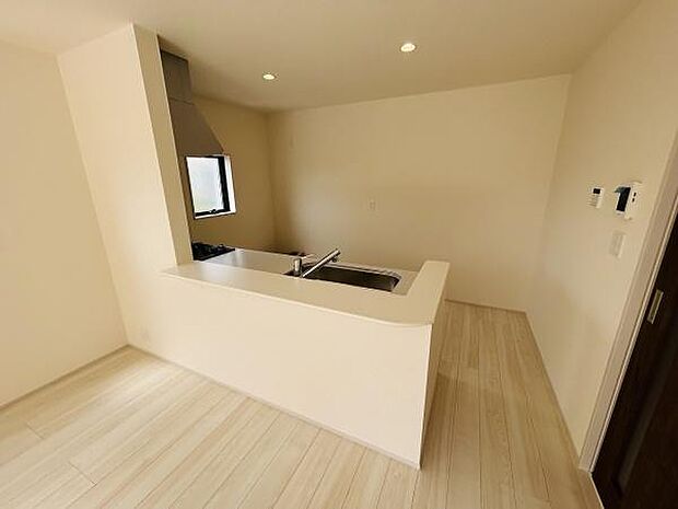 明るい色合いの床材がキッチン全体を広く感じさせます。シンプルなデザインでお手入れがしやすそうです。カウンター付きで使い勝手の良い配置が印象的です。窓があり換気にも配慮されています。