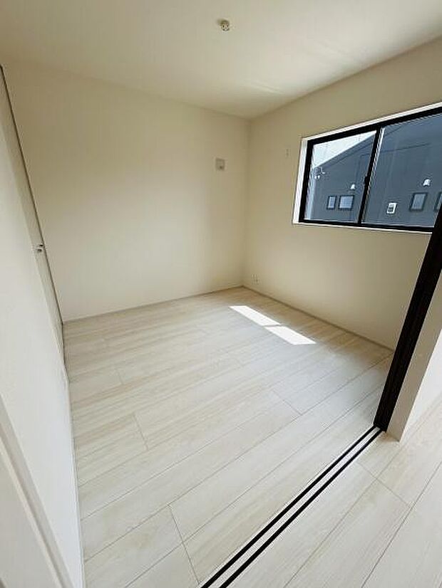 明るい光が差し込む洋室です。床材は落ち着いた色合いで清潔感があります。シンプルなデザインなので家具の配置もしやすいです。窓からの採光もあり快適に過ごせます。