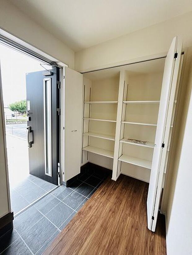 玄関には収納棚が設置されており使い勝手の良いスペースが広がっています。シューズや小物の整理がしやすい造りです。明るい印象の玄関で開放感が感じられます。