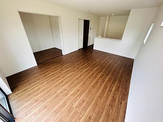 リビングは広々とした空間が特徴です。窓からの採光で明るい雰囲気が広がります。木目のフローリングが落ち着いた印象を与えます。キッチンとの仕切りがあり使い勝手にも配慮されています。