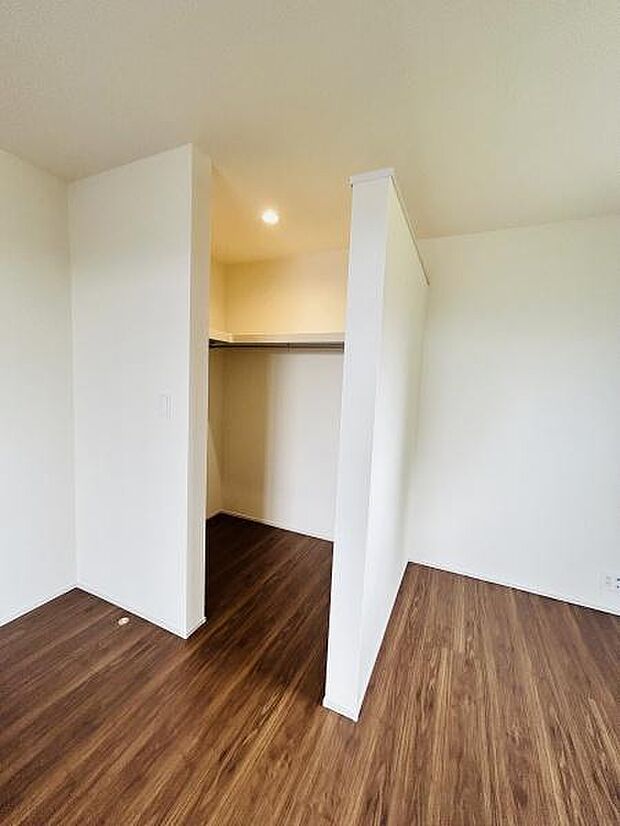 シンプルなデザインの収納スペースが用意されています。開放感のある間仕切りが特徴です。床の色合いと壁のバランスが調和しています。照明が設置されており使い勝手にも配慮されています。清潔感のある空間です。