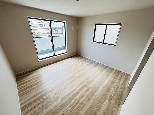 二面採光で明るい雰囲気の寝室です。シンプルな内装が空間を広く感じさせます。バルコニーに面した窓が開放感を演出します。フローリング仕上げでお手入れも簡単です。