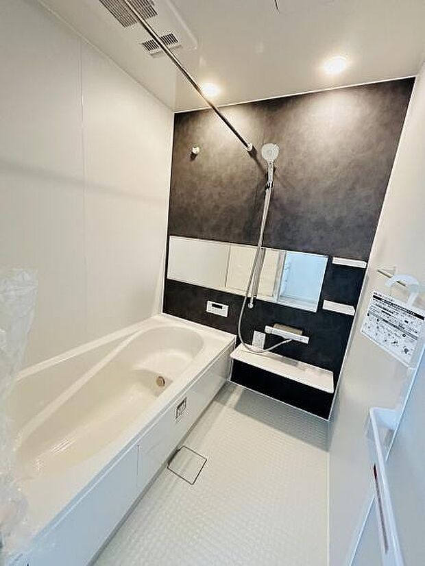 バスルームは洗練されたモノトーンの壁面が特徴です。浴槽や洗い場が使いやすい配置となっています。鏡や収納スペースもまとまっており明るい照明が空間を広く感じさせます。清潔感のある床もポイントです。