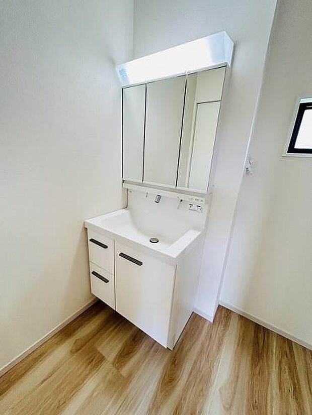 シンプルなデザインが魅力の洗面台です。ミラー収納が備わっておりすっきりとした印象を与えます。ナチュラルな床材が空間を明るく演出しています。コンパクトな造りで使い勝手も意識されています。