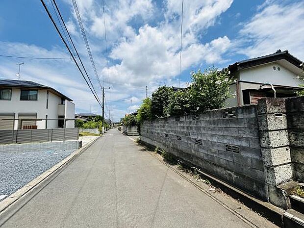 前面道路は広々とした印象で見通しが良好です。住宅街の雰囲気が伝わる現地写真で落ち着いた環境が感じられます。道路の舗装状態も良好で車の通行にも安心です。周辺の家並みも整然としており清潔感があります。