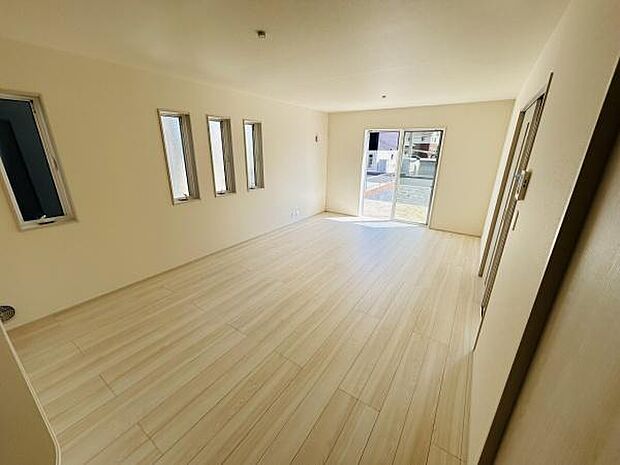 明るい光が差し込むリビングです。床の色合いが空間を広く感じさせます。シンプルな内装でインテリアが映えます。窓が多く風通しも良好です。