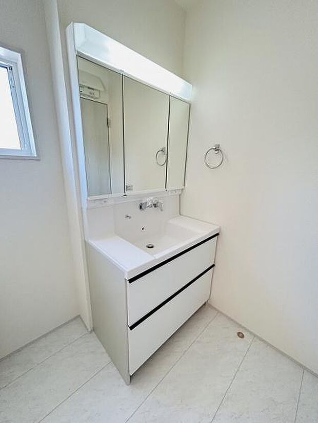 清潔感のあるシンプルな洗面台です。鏡が大きく日常の身支度にも便利です。収納スペースもあり小物の整理がしやすい仕様です。明るい空間づくりに役立つ洗面所です。