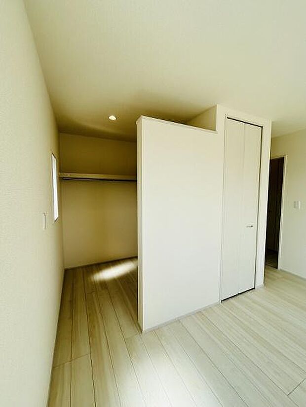 ナチュラルな色合いの収納スペースが室内に設けられています。壁と扉で目隠しができすっきりとした印象です。奥行きのある設計でたっぷり収納が可能です。棚やハンガーポールが活用でき整理しやすい仕様です。