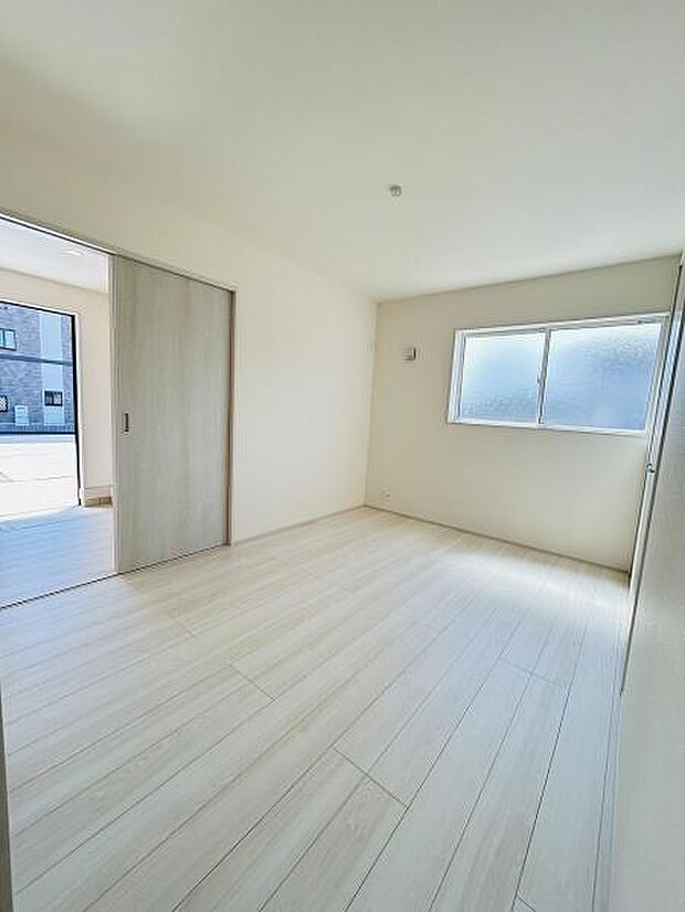 明るい日差しが差し込む洋室です。シンプルな内装でお好みの家具も合わせやすい空間です。スライドドアで他の部屋とつながりやすい設計になっています。フローリングの質感が落ち着いた雰囲気を演出しています。