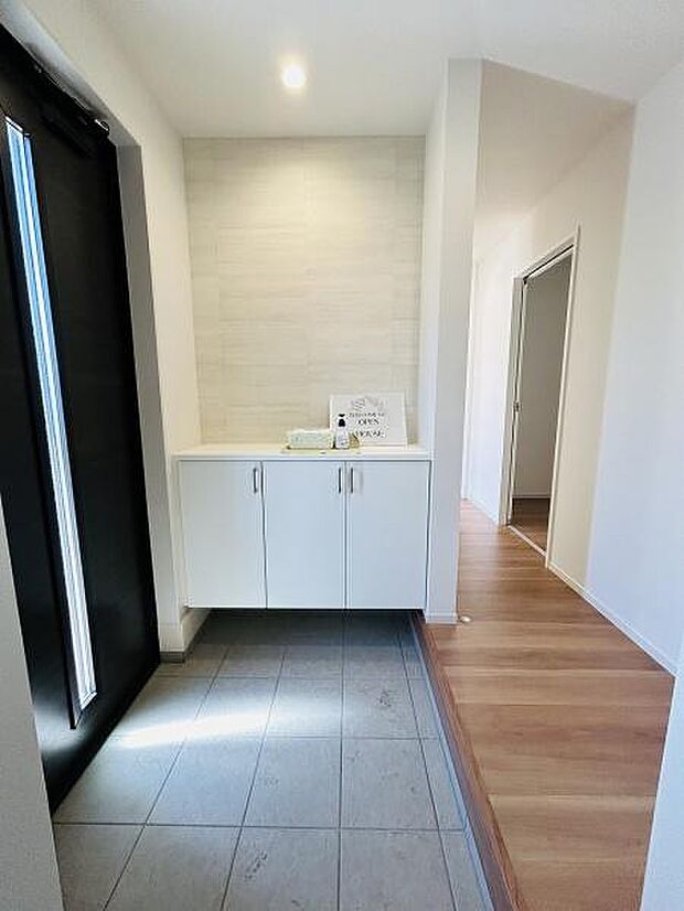 明るい空間が広がる玄関です。白を基調としたシンプルなデザインですっきりとした印象です。収納スペースも備えており整理しやすい玄関です。廊下へとスムーズに繋がっています。