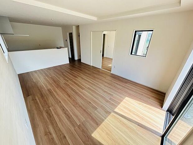 リビングには明るい日差しが差し込む大きな窓があり開放感あふれる空間です。床材はナチュラルな色合いで落ち着いた雰囲気を演出しています。室内全体がシンプルで使いやすい設計となっています。