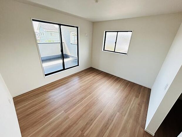 明るい光が差し込む寝室です。バルコニーに面した大きな窓が開放感を演出します。ナチュラルなフローリングが落ち着いた雰囲気を感じさせます。シンプルな内装でインテリアにも合わせやすい空間です。