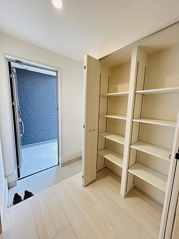 玄関には収納スペースが備わっておりスッキリとした空間が広がります。明るい印象の玄関なので日々の出入りが快適です。収納棚は整理整頓しやすく機能的です。室内と屋外の動線がスムーズに繋がっています。