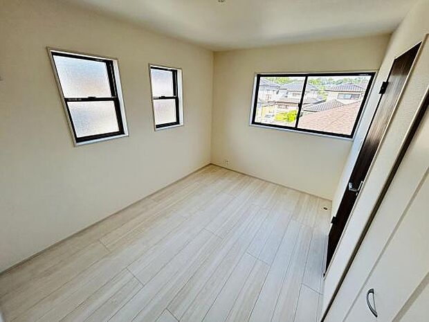 三つの窓が並び室内へ明るい光を取り込めます。シンプルな内装なので様々なアレンジが可能です。収納も備え付けられており整頓しやすい空間です。床の色合いがやわらかく落ち着いた雰囲気を感じられます。