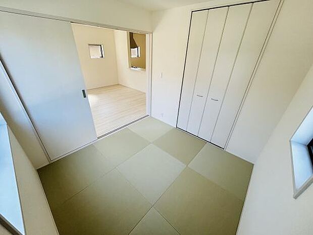 和室はシンプルなデザインで清潔感のある空間です。隣接した洋室とのつながりも良好です。収納スペースも備わっておりすっきりとした印象を与えます。窓からの自然な光も取り入れやすく明るい雰囲気です。