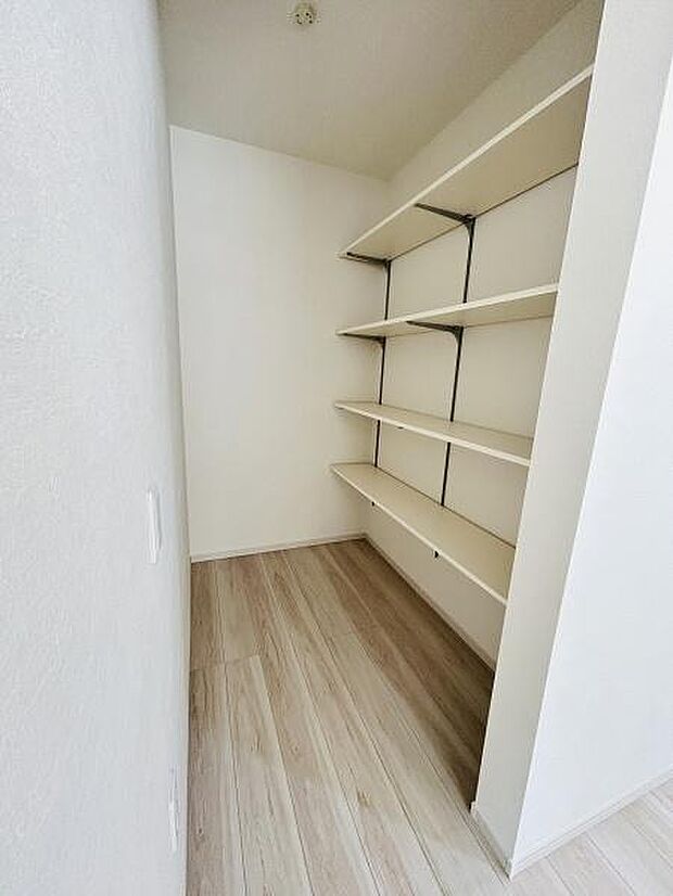 奥行きのある収納スペースで使い勝手の良い可動棚を設置しています。壁面を活用した造りで整理整頓がしやすい設計です。床は明るい色合いで室内全体もすっきりとした印象です。