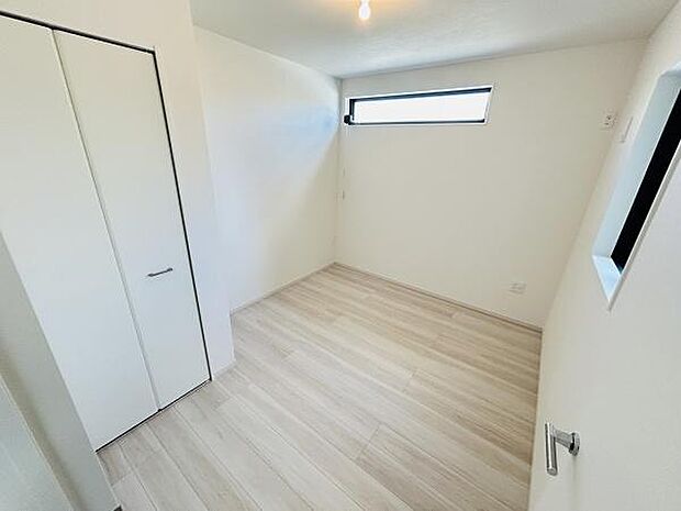 明るさを感じる洋室です。ホワイト系のフローリングが空間を広く感じさせます。スタイリッシュな横長窓から自然光が差し込みます。収納スペースもしっかり確保されています。清潔感ある仕上がりとなっています。