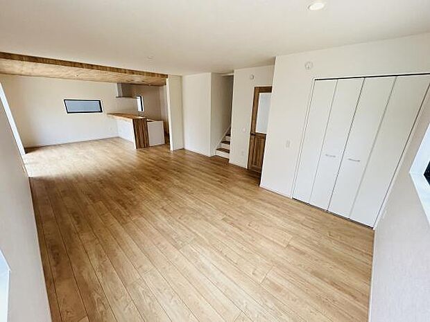 広々としたリビングが印象的で開放感を感じられます。床の木目調が明るい雰囲気を演出しています。収納スペースもありすっきりと整理できます。階段やキッチンとの動線にも配慮されています。