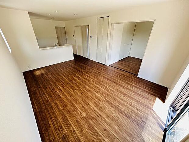 開放感のあるリビングは床の木目が明るく印象的な雰囲気です。室内はシンプルで家具の配置がしやすい造りになっています。隣接したスペースも活用しやすいデザインです。