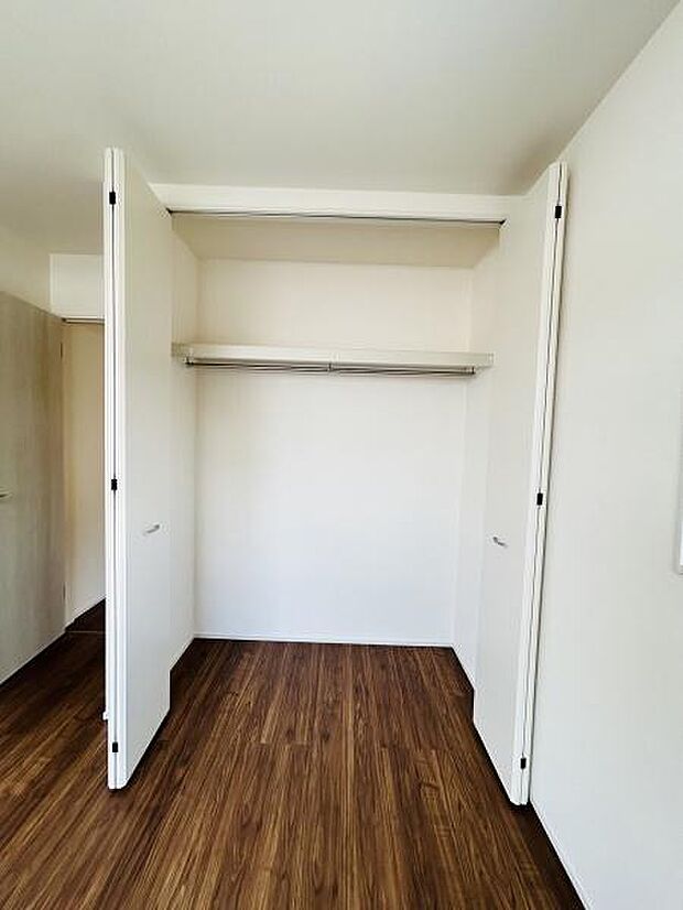 シンプルなホワイトの扉で清潔感があります。奥行きがあり収納スペースがしっかり確保されています。使いやすいバーが備え付けられており衣類の収納に便利です。床と扉のコントラストが空間をすっきりと見せます。