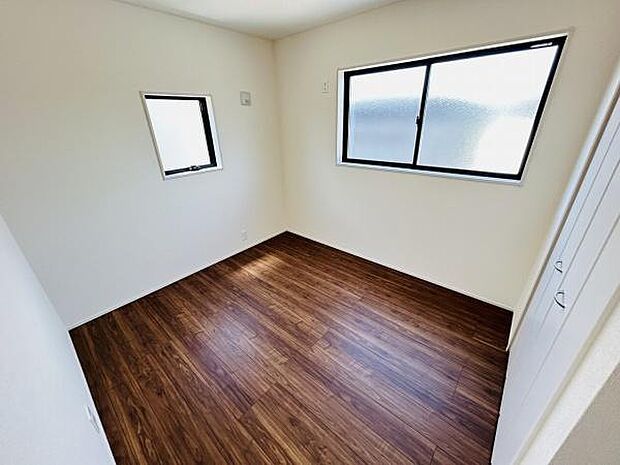 二面採光の明るい洋室です。シンプルな内装で家具の配置がしやすい空間です。落ち着いた色合いの床材が魅力です。クローゼット付きで収納にも困りません。窓から自然光が差し込みます。