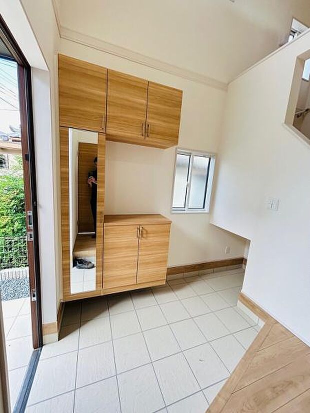 玄関には収納が豊富なシューズボックスが設置されています。大きな鏡があり外出前の身だしなみチェックにも便利です。明るい空間で開放感を感じられるデザインです。小窓があるため換気もしやすい玄関です。