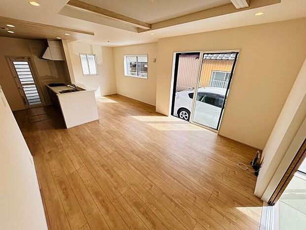 広々とした空間が印象的なリビングです。大きな窓から自然光がたっぷり差し込みます。床面は木目調で落ち着いた雰囲気です。リビングからキッチンへの動線もスムーズです。開放感のある室内で快適に過ごせます。