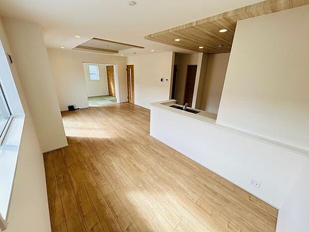 リビングには大きな窓が設けられており室内がとても明るく感じられます。木目調のフローリングが空間をすっきりと演出しています。カウンターキッチンからリビングが一望でき開放感があります。