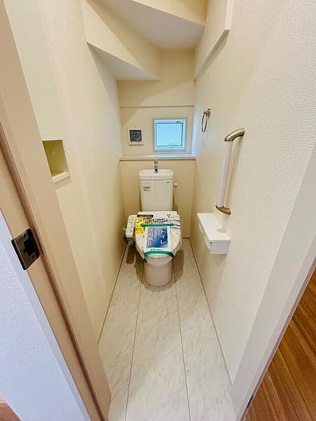 トイレには小窓があり自然な明るさが感じられます。手すりが備え付けられており使いやすさに配慮されています。コンパクトな空間ですが清潔感があります。床材も明るく清掃がしやすそうです。