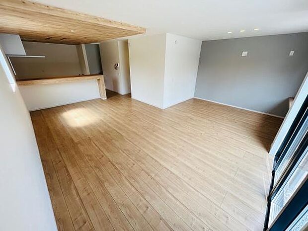 ナチュラルなフローリングが広がる開放感のあるリビングです。木目調の天井とカウンターがアクセントとなっています。落ち着いたトーンの壁が空間を引き締めます。