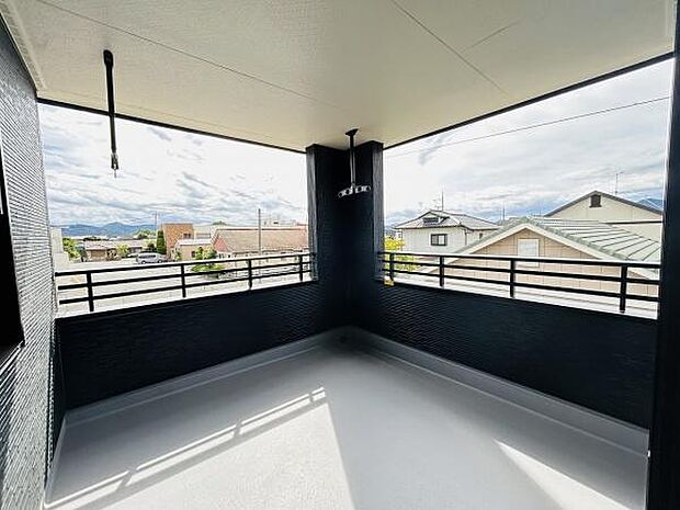 開放的な空間が広がるバルコニーです。ゆったりとしたスペースがあり周囲の景色も見渡せます。屋根付きなので天候を気にせず利用できます。手すりも高めで安心感があります。