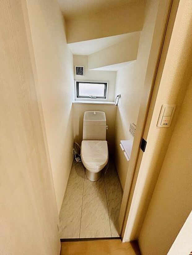 窓があり採光が感じられるトイレです。空間がすっきりしていて清潔感のある内装です。白を基調とした落ち着いた雰囲気が広がります。シンプルなデザインで使いやすさを重視しています。