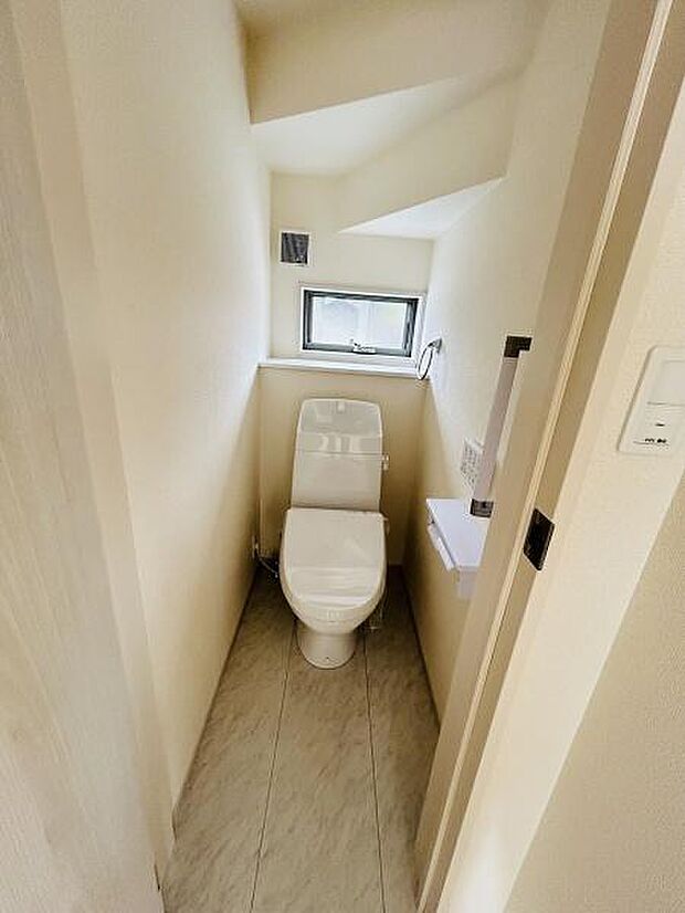 小窓からの自然光が入るトイレです。明るく清潔感のある空間が広がります。コンパクトながらも使いやすい設計になっています。天井の形状が特徴的で視覚的なアクセントにもなっています。