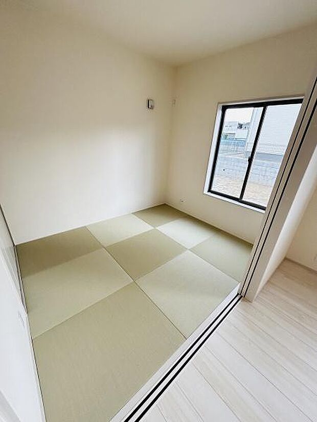 シンプルなデザインが印象的な和室です。窓からは自然光が入り穏やかな空間を演出します。明るい色合いの畳が室内に開放感を与えてくれます。隣接するフローリングとの調和も魅力です。