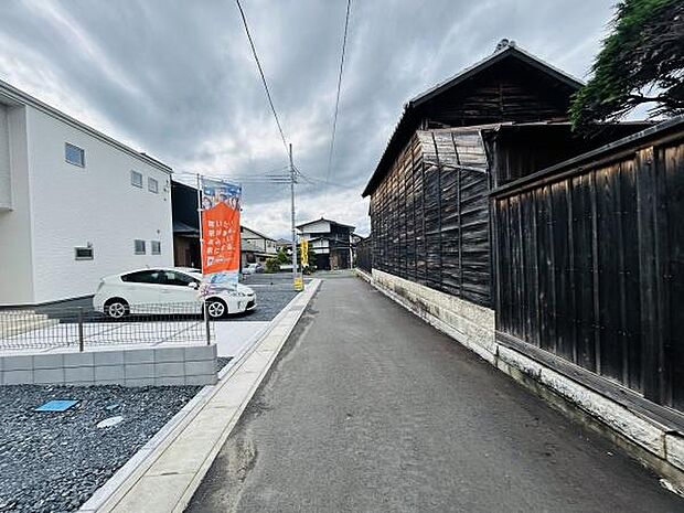 現地写真から前面道路の幅や舗装状態が分かります。周辺の建物も写っており街並みの雰囲気を感じられます。車の出し入れもスムーズに行える道路幅が確認できます。落ち着いた住宅街の一角としてご検討いただけます。