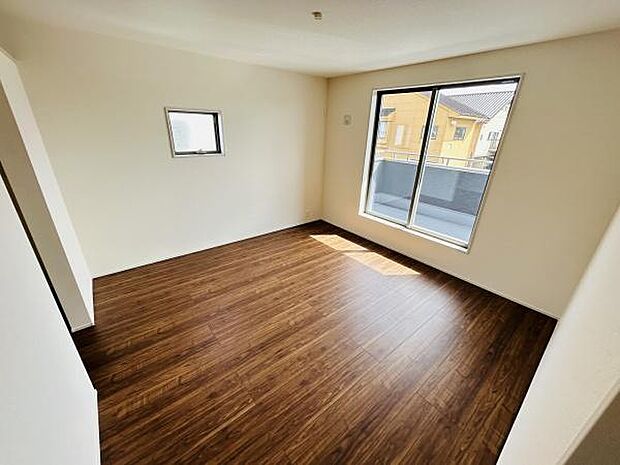 大きな窓から明るい光が差し込み開放感のある寝室です。落ち着いた色合いのフローリングが上品な印象を与えます。角部屋ならではの二面採光が魅力的です。シンプルな内装で様々なインテリアに合わせやすい空間です。