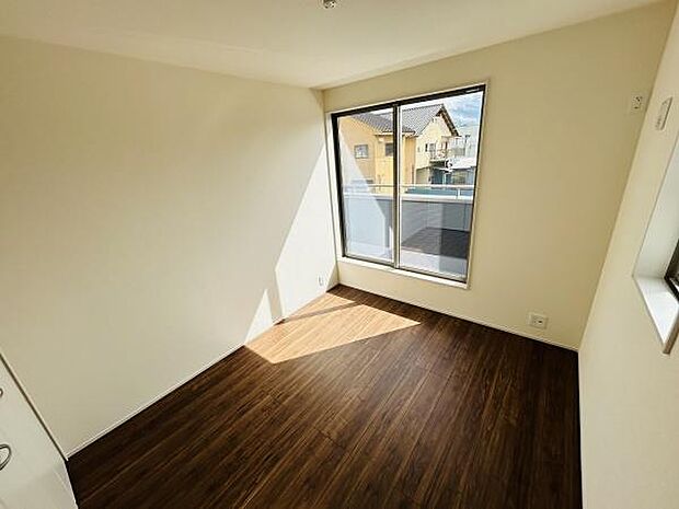 明るい日差しが差し込む窓が特徴の子供部屋です。清潔感のある内装で落ち着いた雰囲気を演出しています。収納スペースもしっかり確保されており整頓しやすい空間です。床材の風合いが温かみを感じさせます。