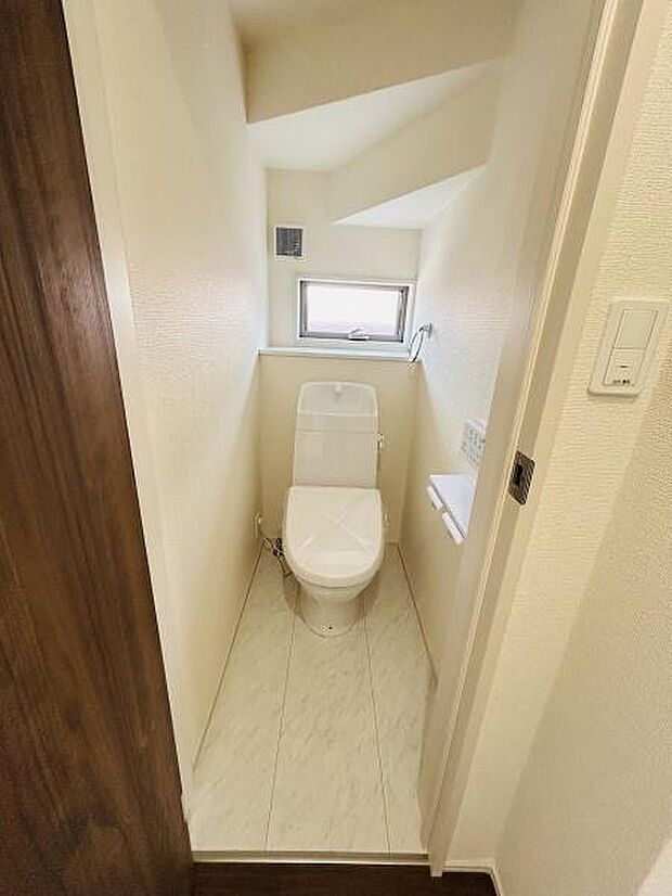 コンパクトな空間に配置されたトイレはシンプルな内装で清潔感があります。小窓が設けられているため換気や採光もしやすい仕様です。床材とのコントラストがすっきりとした印象を与えます。