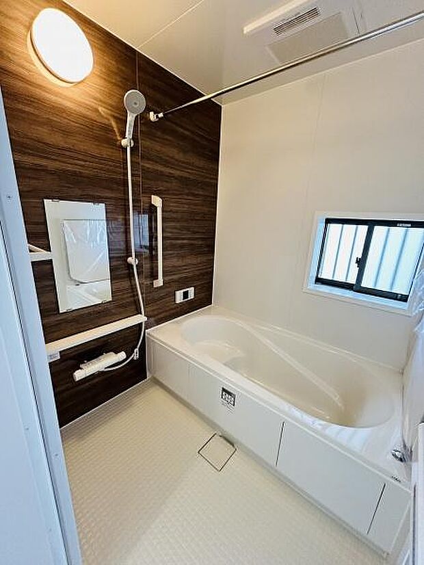 木目調のアクセントパネルが落ち着いた雰囲気を演出しています。浴槽はゆったりとしたサイズ感で快適にご利用いただけます。浴室乾燥機や換気窓も備わっており衛生面にも配慮されています。