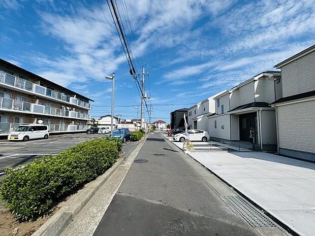 道路幅がしっかり確保されており車両の出入りもスムーズに行えます。周辺には整備された歩道があり見通しの良い直線道路が印象的です。隣接する住宅や施設も新しく清潔感が感じられます。