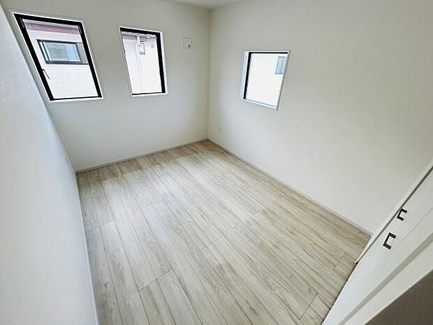 シンプルな内装が特徴の子供部屋です。3面に窓があり自然光を取り込みやすい設計となっています。フローリングは木目調で落ち着いた印象を与えます。収納スペースも確保されています。